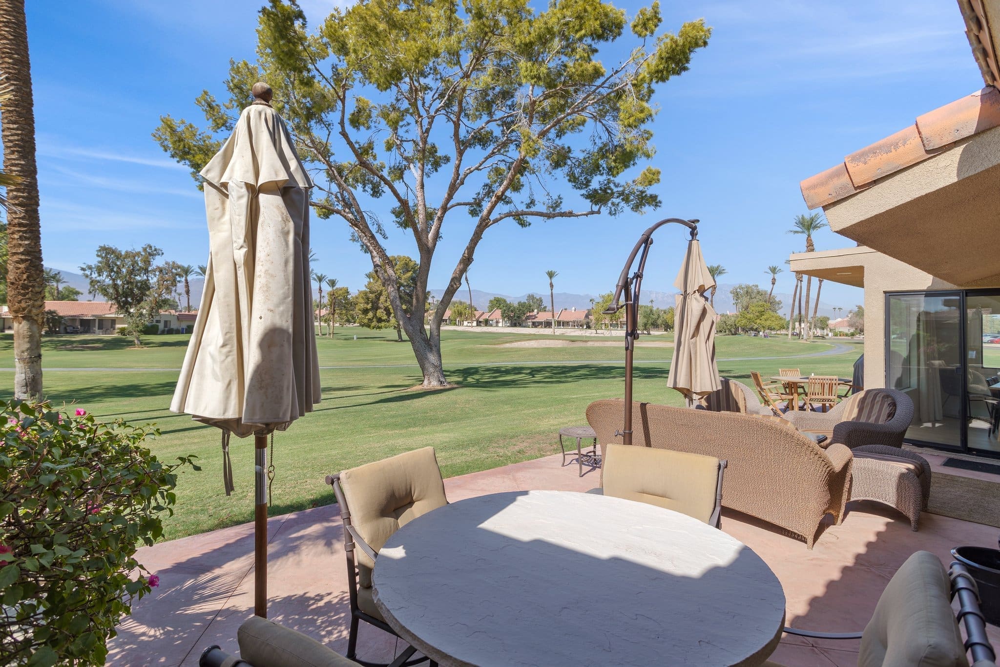 Tan patio set with umbrellas and chairs at 41443 Inverness Way