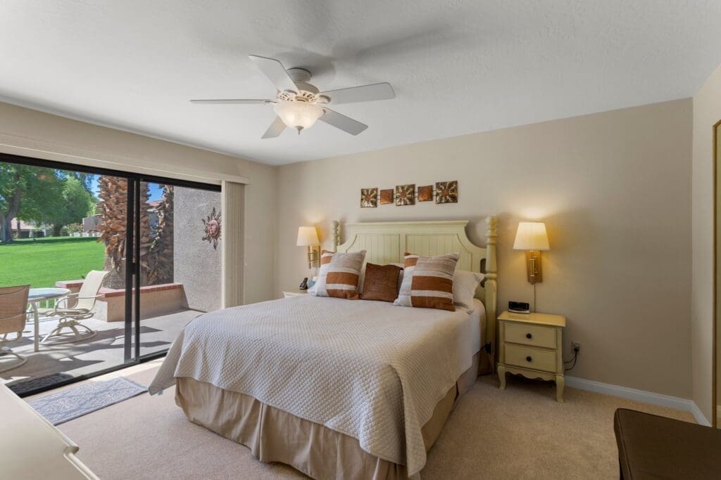 Master bedroom view of bed and sliding glass doors leading to the patio at 40386 Pebble Beach