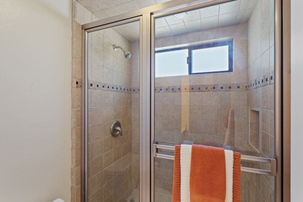 Bathroom area with glass shower doors and stone aesthetic at 77042 Pauma Valley Way