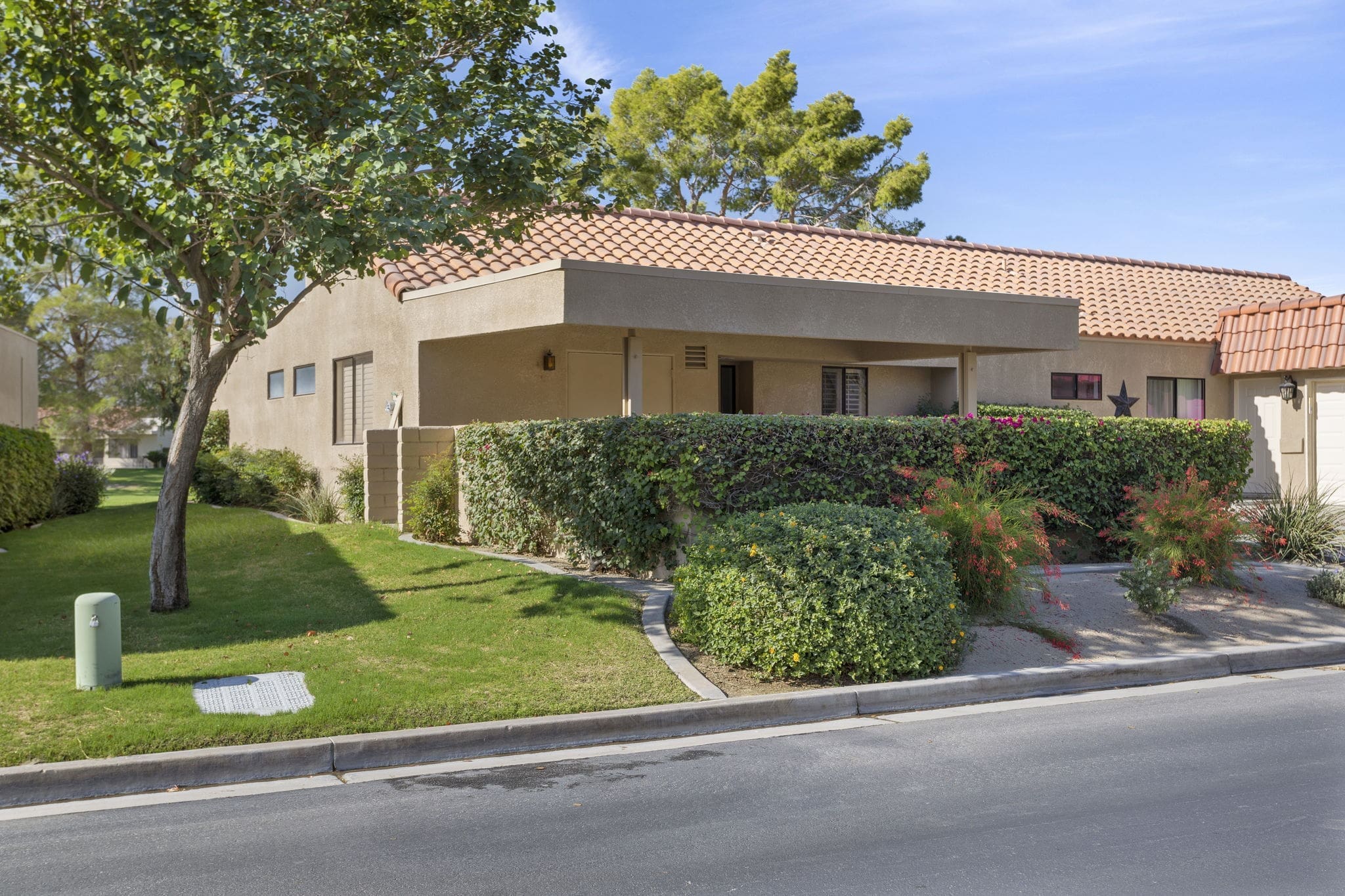 Front side view of 41447 Inverness Way with bishes and trees