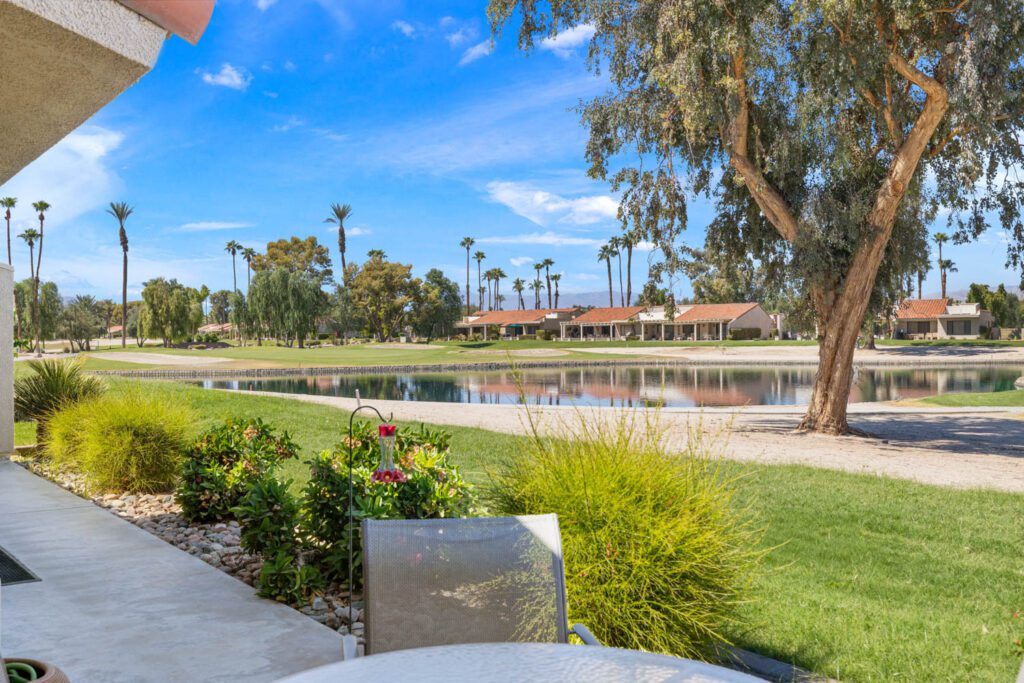 view of patio, golf course and lake