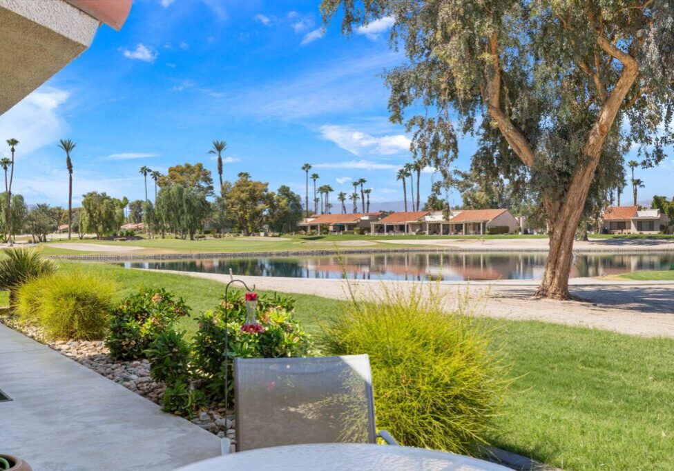 view of patio, golf course and lake